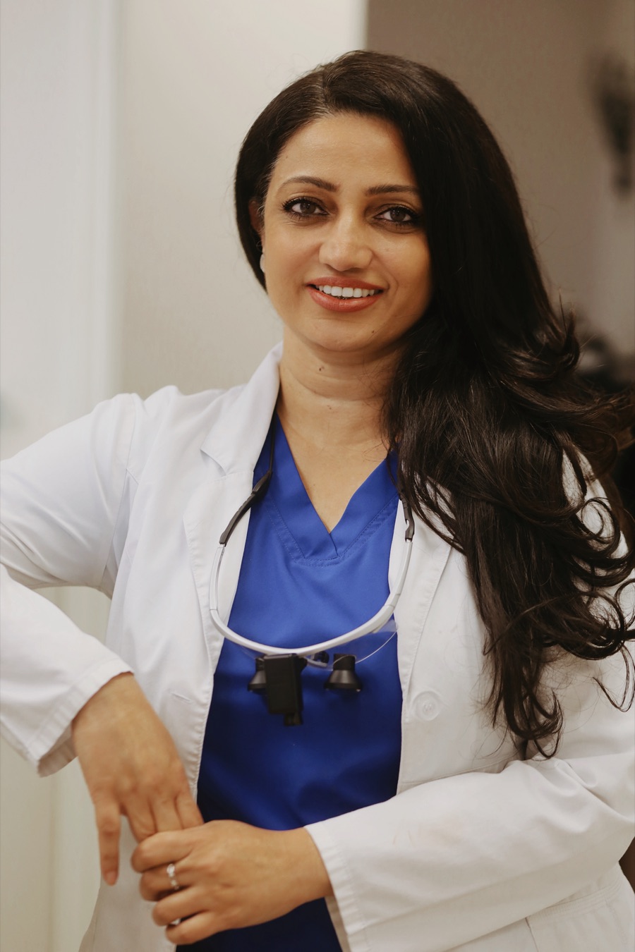 Dr. Parveen Bhatti in a white coat, smiling